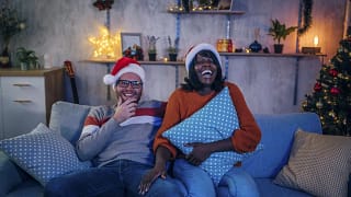 Couple in Santa hats watching a movie on the .width .jpg