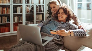 Pregnant woman holding credit card while usin.width wZepwEk.jpg