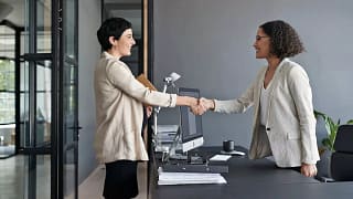 Two professionally dressed women shaking hand.width yGZVL.jpg
