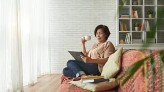 Woman drinking coffee on couch vdWRM.width .jpg