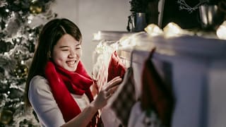 Woman hanging Christmas stocking over firepla.width .jpg
