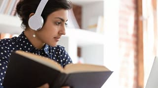 Woman looking up information in a book UQEKk.width .jpg