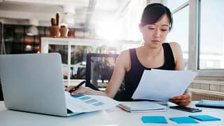 Woman reading papers in office ORTBpP.width .jpg