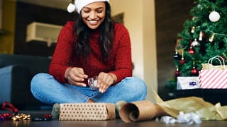 Woman wearing Santa hat wrapping gifts RKFz.width .jpg