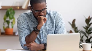 person feeling worried looking at a laptop.jpg