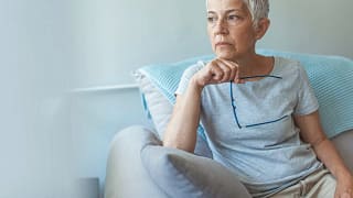 person sitting in a chair holding eyeglasses.jpg