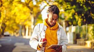 person with apple and tablet outside trVQlI.width .jpg