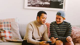 smiling couple discussing something on smartphone.jpg