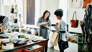 two women swiping credit card in store tjKpb.width .jpg