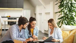 Couple signing paperwork with realtor.width .jpg