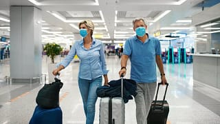 Mature couple walking through airport with lu.width LWcByxn.jpg
