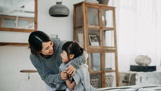 Mother wrapping blanket around young daughter.width wZbBjIn.jpg