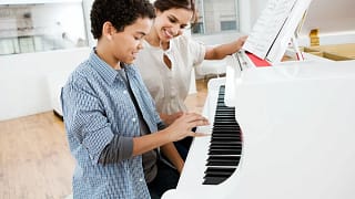 Woman giving young boy piano lessons lHvgOq.width .jpg