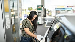 Woman refueling her car at a gas station tn.width .jpg