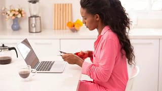Woman sitting in front of her laptop cutting .width GXFCLY.jpg