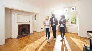 couple with realtor in empty living room.width .jpg