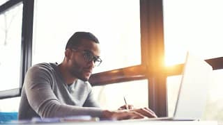 man on laptop near window.width .jpg