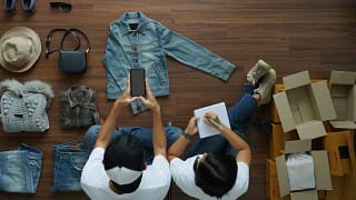 people selling used clothes sitting on floor.width .jpg