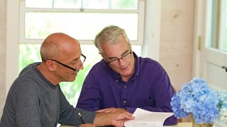 senior gay couple looking at documents finances.jpg