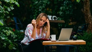 woman outdoor cafe with laptop and notebook.width .jpg