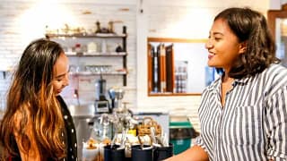 woman paying at restaurant counter with credi.width zPwJXz.jpg