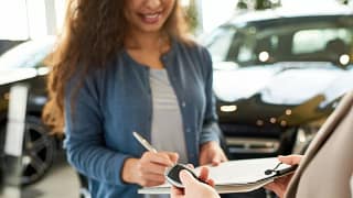 woman signing car paperwork xpccuHh.width .jpg