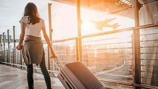 woman with suitcase in airport kihmYKH.width .jpg