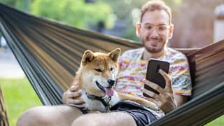 Man on hammock looking at his smartphone whil.width wANIld.jpg