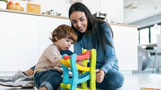 Mother and young son play with car toys toget.width .jpg