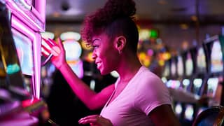Person smiling while using slot machine in a .width .jpg
