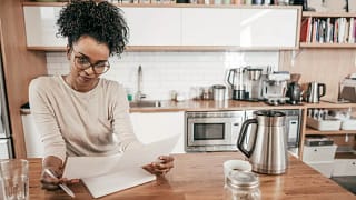 Woman sits in kitchen looking over personal f.width DSfPgo.jpg