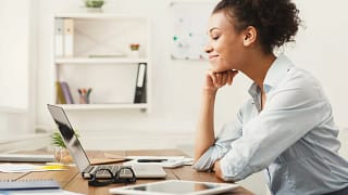Woman smiling at office desk TGyhOjd.width .jpg