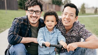 getty happy couple posing outside with child.jpg