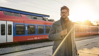 man with suitcase in front of train.width .jpg