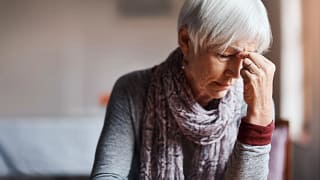 older woman pinching top of nose gettyimages .jpg