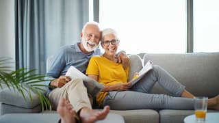 senior couple smiling on couch gettyimages .jpg
