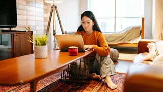 woman on living room floor with laptop.width bGokC.jpg