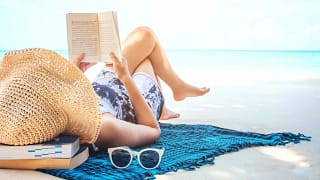woman reading book on the beach GettyImages .width qPLFmi.jpg