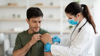 Healthcare worker putting bandaid over vaccin.width .jpg