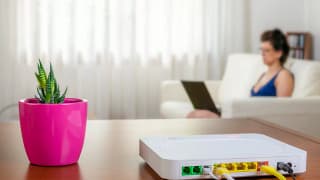 Internet router in foreground with woman usin.width VDwzYv.jpg