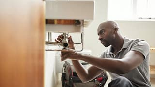 Man fixing plumbing under sink HIULjzU.width .jpg