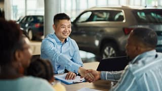 Salesman and customer shaking hands over pape.width .jpg