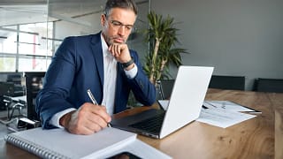 man s biz suit desk taking notes gettyimages .jpg