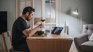 man drinking wine on video call.width .jpg