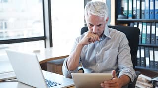 older man desk tablet serious gettyimages .jpg