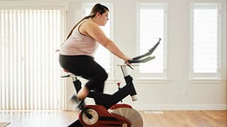 person on exercise bike at home kRawtlc.width .jpg