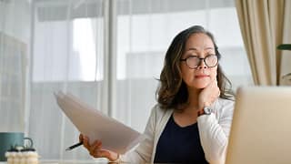 senior holding documents and looking at computer.jpg