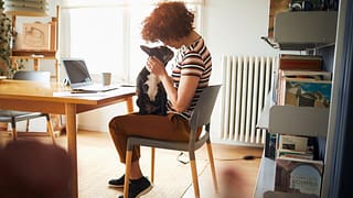 woman at desk with dog on lap cLXvUl.width .jpg