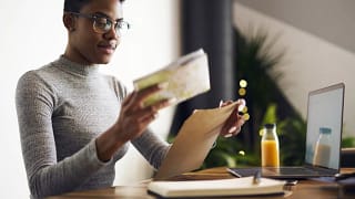 Woman with paperwork and laptop.width .jpg