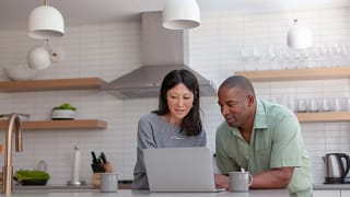 couple staring at computer in kitchen.jpg